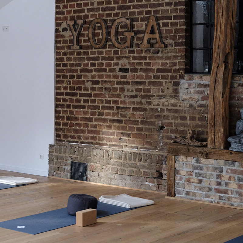 Yogastudio mit Yoga Schriftzug an der Wand