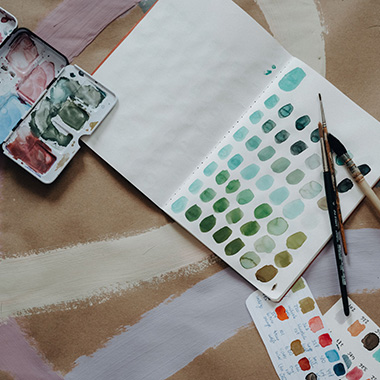 Farbpalette im Journal mit Pinseln und Aquarellfarben